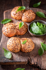 Tasty spinach buns freshly baked on wooden board.