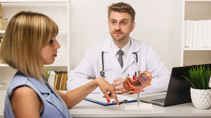 Young woman on a consultation with a male surgeon or therapist in his office.