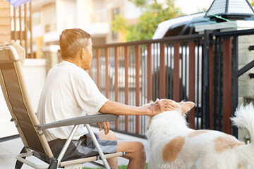 Back view of the old man sitting Alone and he dog.