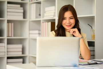 Confident female manager watching online webinar on laptop screen. Business, communicating and technology 
