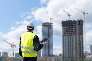 Engineer with a digital tablet on the background of a building under construction	
