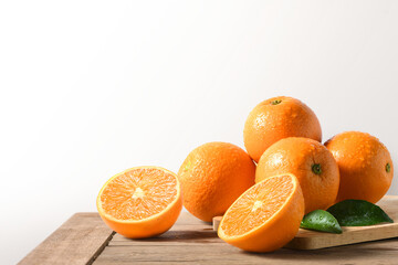 Fresh oranges with cut in half on wooden table.