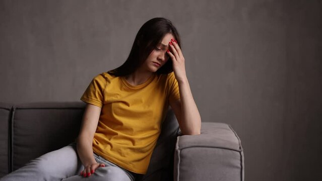 Young woman sad cry  while sit on the couch in living room