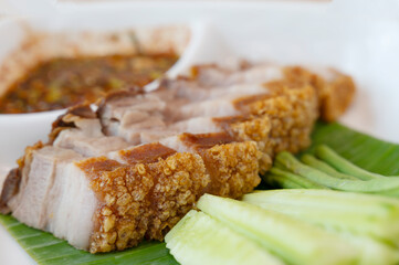 Deep-fried pork belly on a plate with fresh greens