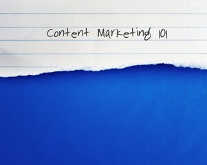 Torn lined note paper with text written Content Marketing 101 , on blue background with copy space. Concept of how to use content marketing to achieve in business