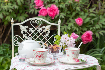 Tischdekoration mit Teegeschirr im Frühlingsgarten	