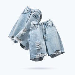 Ripped jeans shorts flying on blue background. Female fashionable denim cloth. Advertising for trendy ladies store, blog. Creative concept Summer Women's Clothing. Branding clothes. Mock up for design