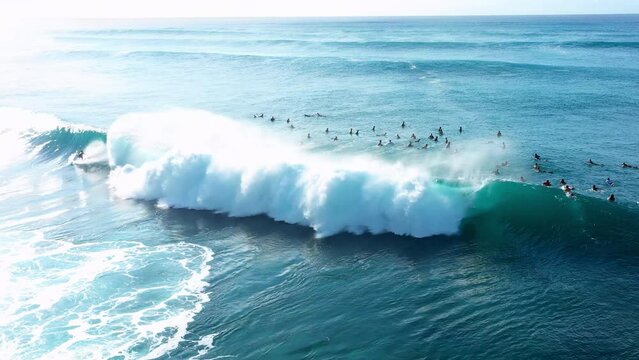 Aerial Backward Panning Shot Of Tourists Surfing On Waves In Sea During Sunny Day - Oahu, Hawaii