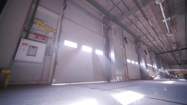 Construction process of a big, modern warehouse with multiple garage gates for easy access and transportation of goods.