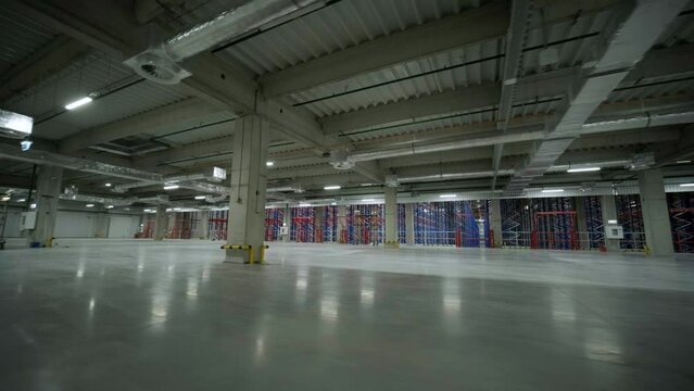Big and modern warehouse under construction, featuring metal shelving and other industrial equipment.