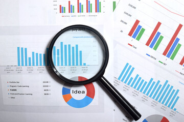 Magnifying glass on charts graphs paper. Financial development. Business office concept.