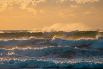 Layers of wave with sunrise golden light.