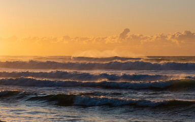 Layers of wave with sunrise golden light.
