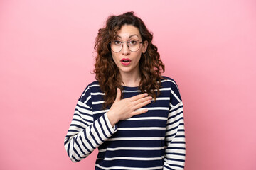 Fototapeta premium Young caucasian woman isolated on pink background surprised and shocked while looking right
