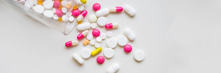 Pile of colorful medicine pills on white background, top view,selective focus.Global healthcare concept. Antibiotics drug resistance. Antimicrobial capsule pills. Pharmaceutical industry.copy space