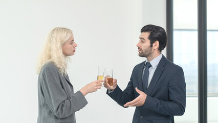 Businessman and businesswoman drinking champagne to celebrate success of investment agreement after meeting, teamwork and partnership concept.
