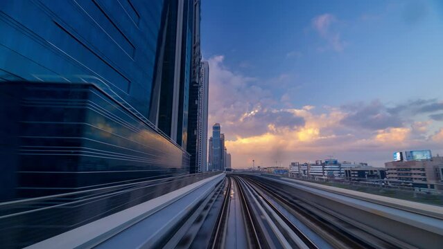 Time lapse Hyper lapse high speed Dubai Metro travel along sheikh Zayed road passing high rise building in downtown during beautiful sunrise