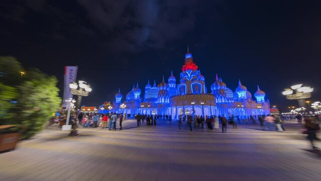Time lapse Hyper lapse walking in Dubai Global village show miniature Saint Basil's Cathedral with visitors at night.