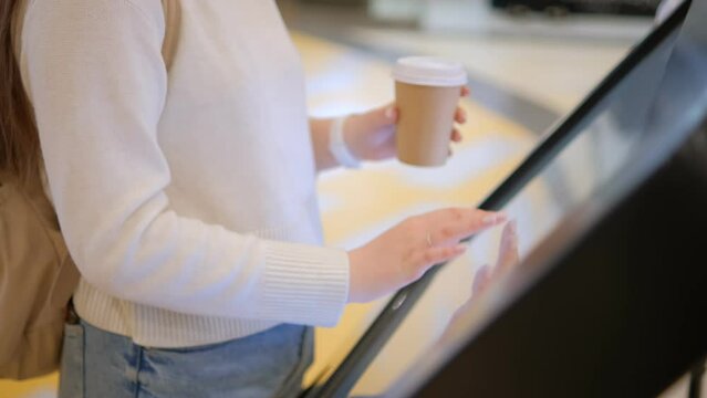 Young Woman looking for information and location of shopping place on digital touch screen in shopping mall 4K