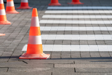 Orange traffics cones and new marking of pedestrian crossing in city