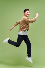 Full size photo of young happy excited crazy positive man jumping hold fists in victory - 599852944