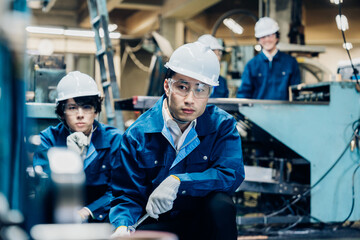 Fototapeta na wymiar 工場で機械の整備をする労働者