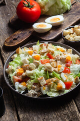 Salad of iceberg leaves, chicken, eggs and tomatoes in a plate. Caesar salad