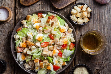 Salad of iceberg leaves, chicken, eggs and tomatoes in a plate. Caesar salad