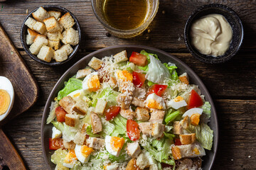 Salad of iceberg leaves, chicken, eggs and tomatoes in a plate. Caesar salad
