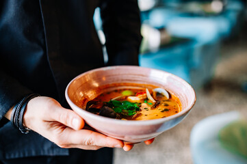 chef hand hold bowl with seafood soup