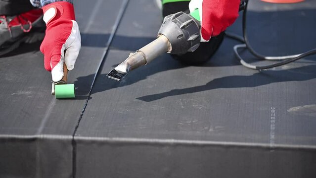 Roofer Installing EPDM Rubber Roofing Membrane