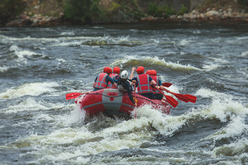 Red raft boat during whitewater rafting extreme water sports on water rapids, kayaking and canoeing on the river, water sports team with a big splash of water