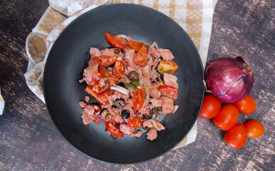 bluefin tuna salad with onions tomatoes capers and garlic on a dark background quick beach meal
