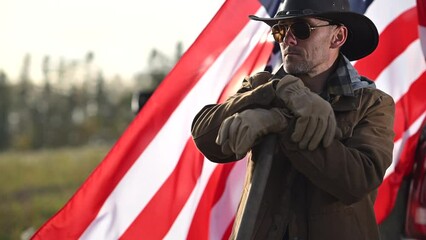 Cowboy Against Backdrop of US Flag Ruffling in the Wind