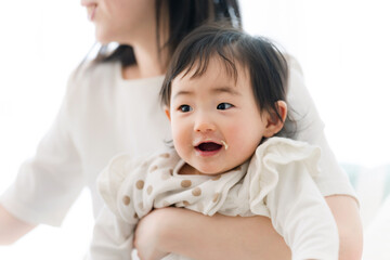 赤ちゃんに離乳食を食べさせるママ