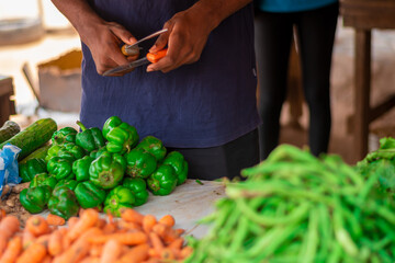close-up shot, black trader sharpen knives to sell fruits