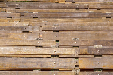 Frontal view of permanent wooden benches, affixed to conglomerate spacers or stabilizers, in an outdoor amphitheater in a botanical park in central Florida, for motifs of events, public gatherings