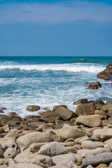 Pantai Klayar or Klayar Beach with rocks and strong waves against the blue sky