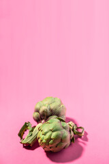 Fresh green artichokes isolated on pink background