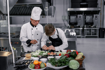 Teenagers learn from expert chefs at culinary school to prepare ingredients and create a variety of...