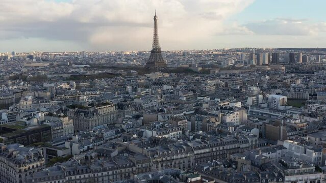 Flying towards Eifel Tower above typical old urban grid of Paris, France. Late afternoon light, historical building rooftops