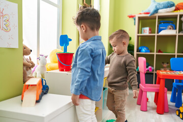 Adorable boys standing with relaxed expression playing at kindergarten