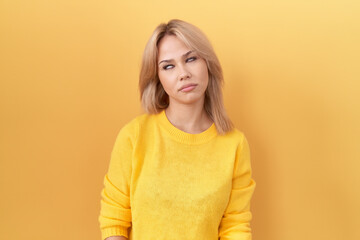 Obraz premium Young caucasian woman wearing yellow sweater looking sleepy and tired, exhausted for fatigue and hangover, lazy eyes in the morning.