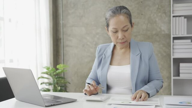 Senior businesswoman working with financial graph document on laptop computer Female financial advisor discussing retirement savings details working from home 4k