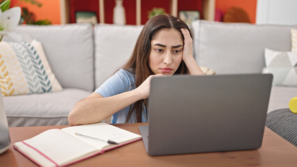 Naklejka premium Young beautiful hispanic woman smiling confident using laptop at home