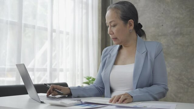 Senior businesswoman working with financial graph document on laptop computer Female financial advisor discussing retirement savings details working from home 4k