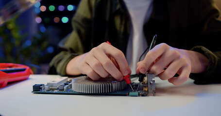 Close Up. Engineer soldering microcircuit. Unknown male hands with a tool repairs a home electronic...