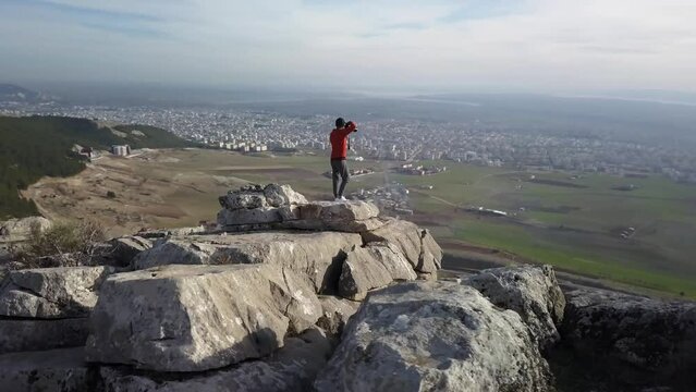 the man taking a picture of the city on the mountain top scene