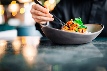 man hand eat chicken curry rice holding chopsticks