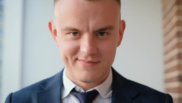 Insidious cunning man in a business suit smiling looking at the camera, close-up